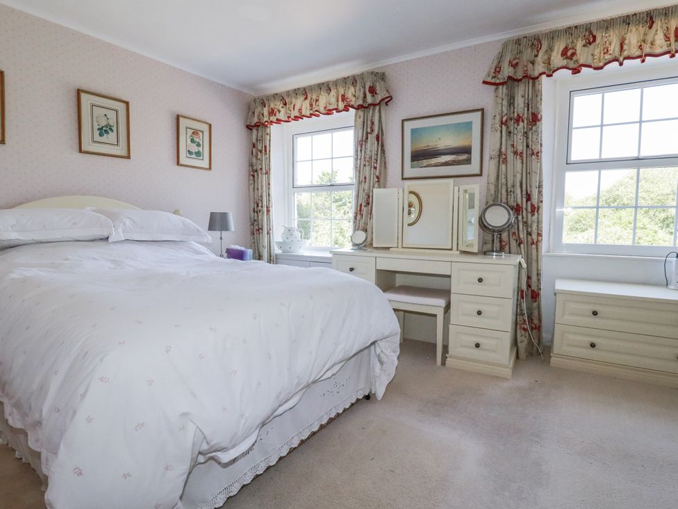 A bedroom with a bed and dresser at Temple House in Goonhavern