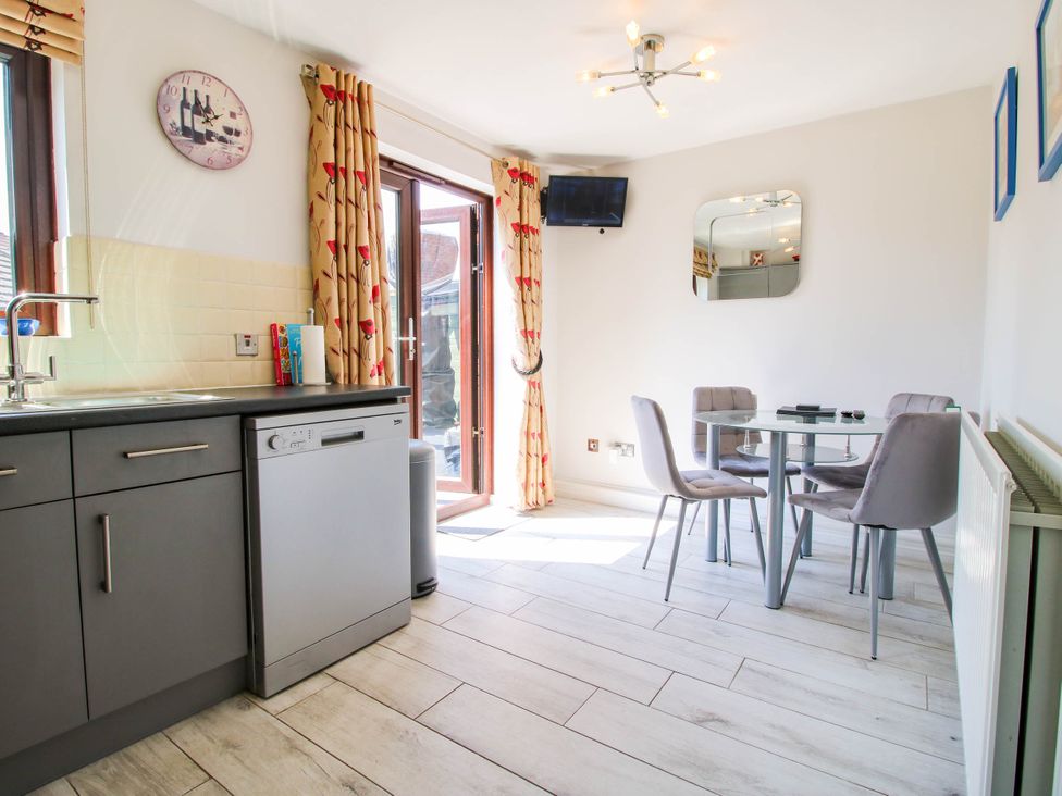 A kitchen and dining area with a dishwasher glass table and four chairs at 63 Severn Street in Bridgnorth