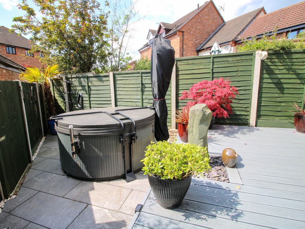 A garden with a hot tub potted plants and a stone sculpture at 63 Severn Street in Bridgnorth