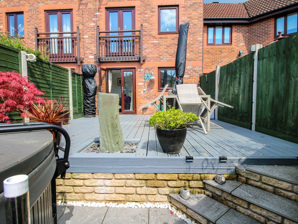 A backyard deck with patio chairs a potted plant and fenced boundaries at 63 Severn Street in Bridgnorth