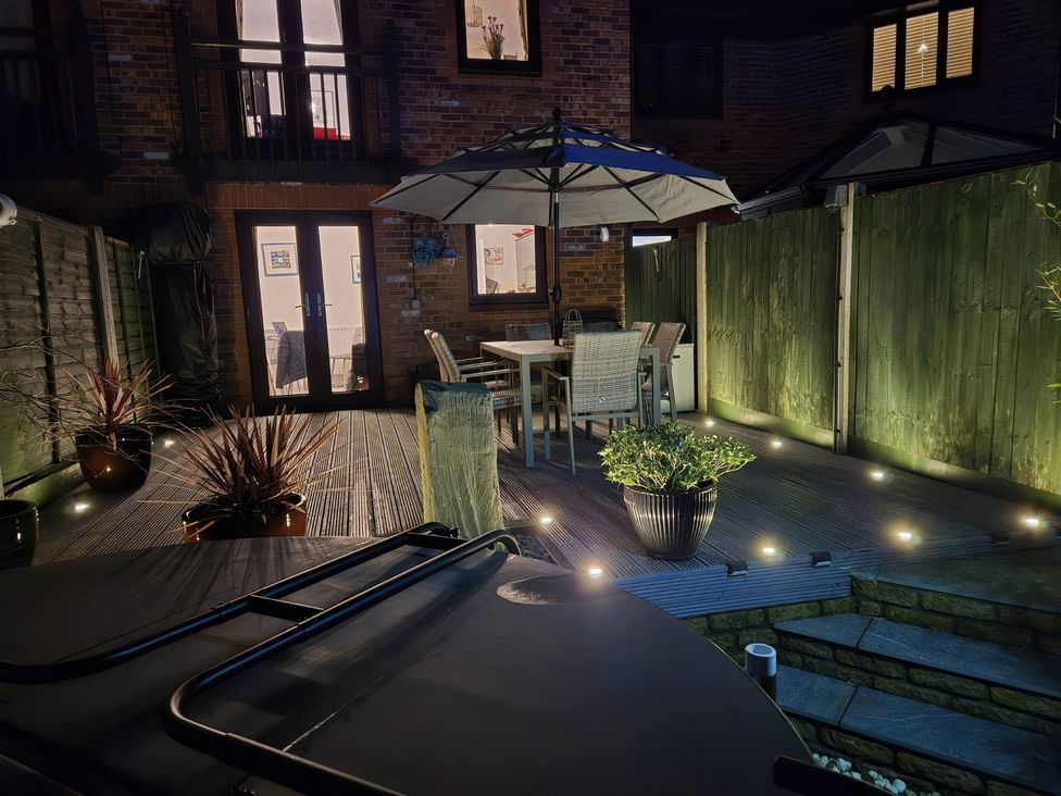 A garden with a dining set and potted plants at 63 Severn Street in Bridgnorth