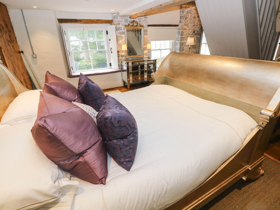 A bedroom with a bed and decorative pillows at The Apple Store at Gileston Manor in Gileston near St Athan