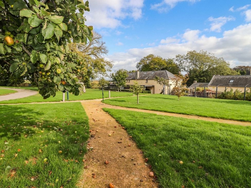 A garden with a path and a house in the background at The Apple Store at Gileston Manor, Gileston near St Athan
