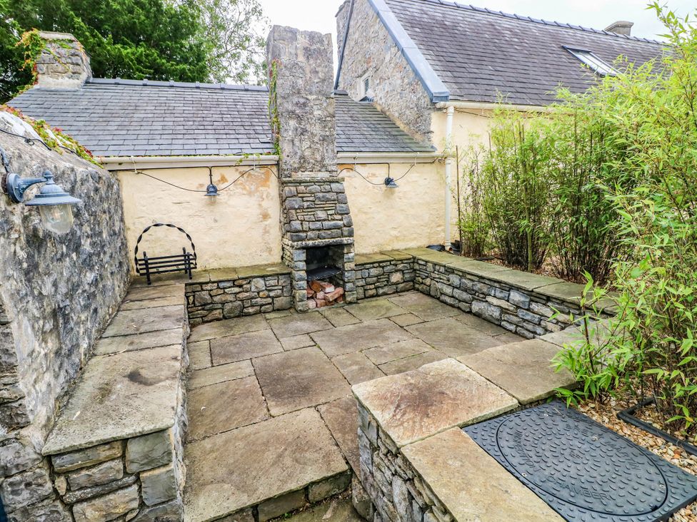 An outdoor patio with a stone fireplace at The Apple Store at Gileston Manor, Gileston near St Athan