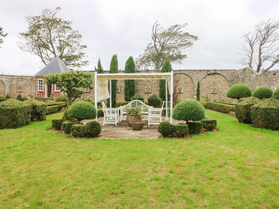 A garden with seating area and topiary at The Apple Store at Gileston Manor in Gileston near St Athan