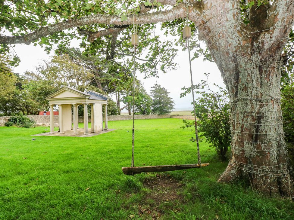 A garden with a swing and a pavilion at The Apple Store at Gileston Manor Gileston near St Athan