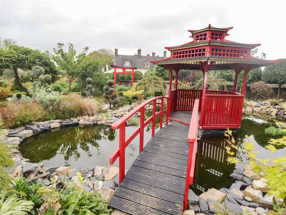 A garden with a red pagoda and pond at The Apple Store at Gileston Manor near St Athan