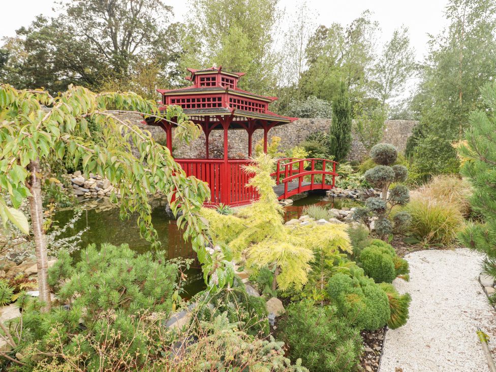 A garden with a gazebo and pond at The Apple Store at Gileston Manor Gileston near St Athan