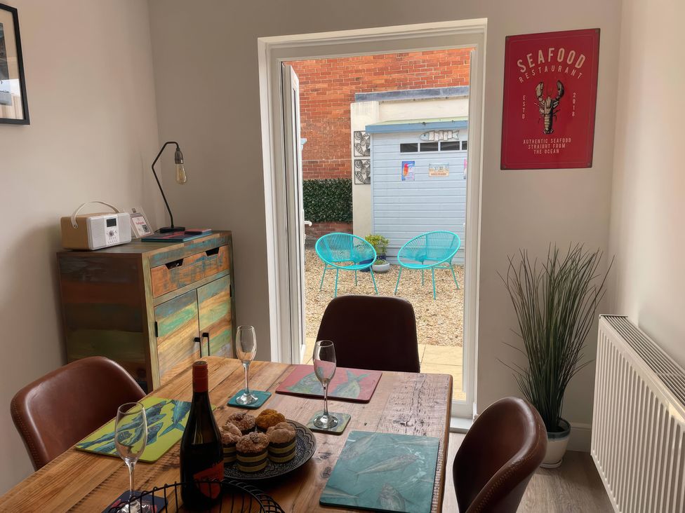 A dining room with a table and chairs at Plain Sailing in Weymouth