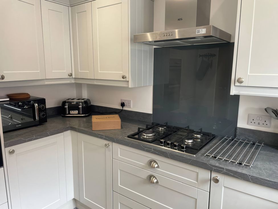 A kitchen with cabinets and stove at Plain Sailing in Weymouth