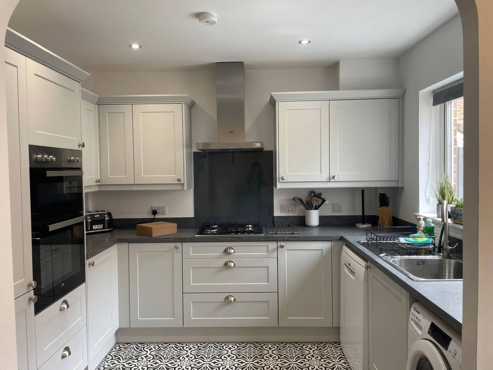 A kitchen with cabinets and appliances at Plain Sailing in Weymouth