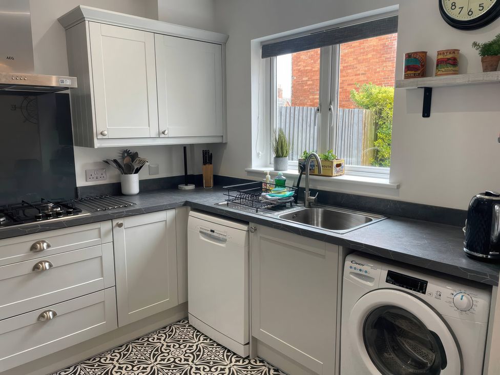 A kitchen featuring a sink, dishwasher, and stove at Plain Sailing in Weymouth