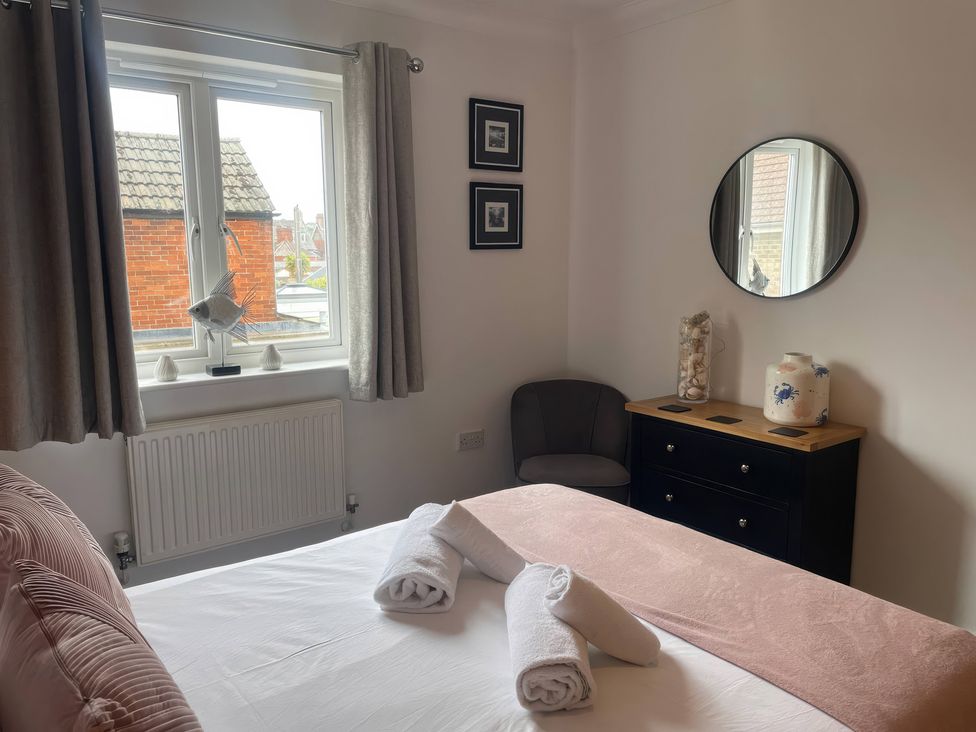 A bedroom with a bed and a dressing table at Plain Sailing in Weymouth