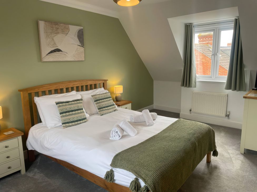 A bedroom with a bed and side tables at Plain Sailing in Weymouth