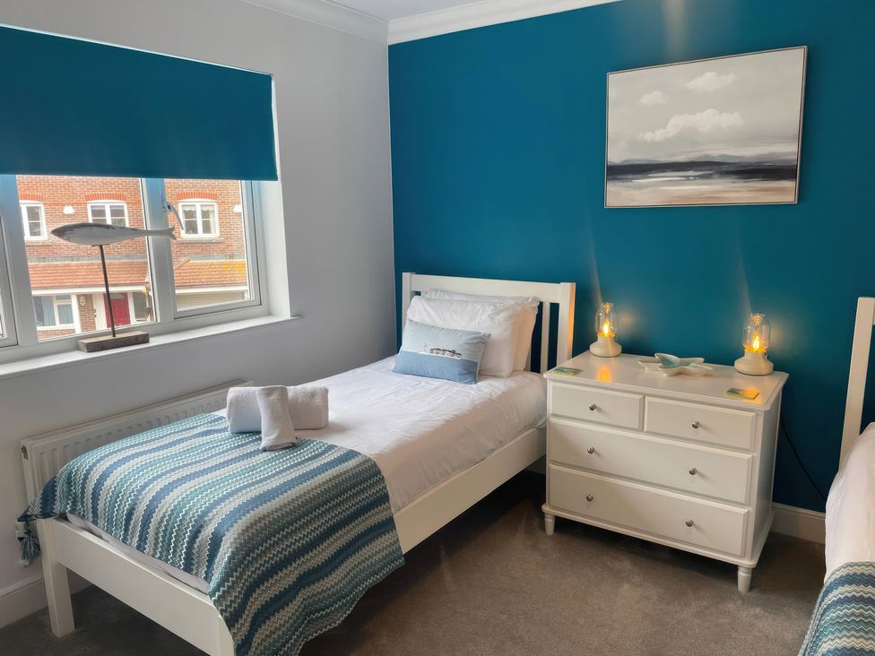 A bedroom with two beds and a chest of drawers at Plain Sailing in Weymouth