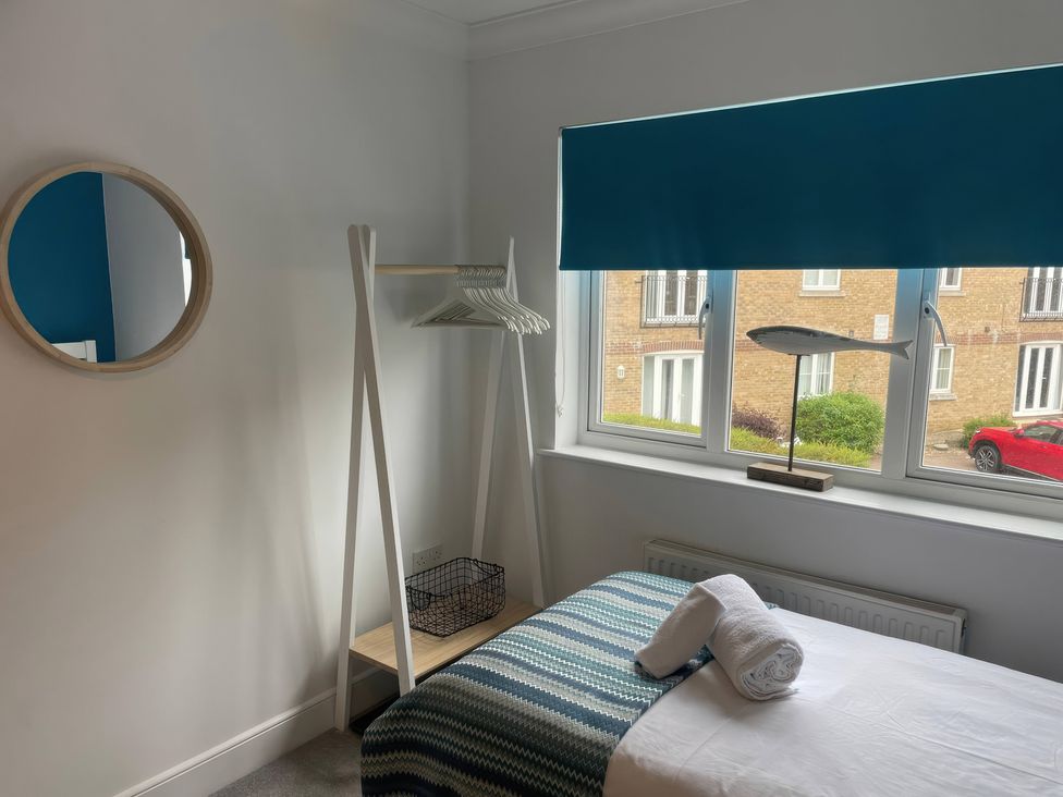 A bedroom with a bed and coat rack at Plain Sailing in Weymouth