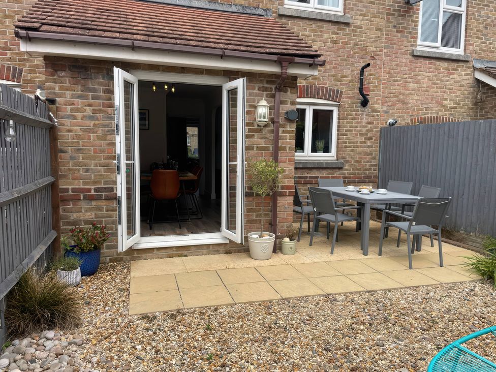 A patio area with a table and chairs at Plain Sailing in Weymouth