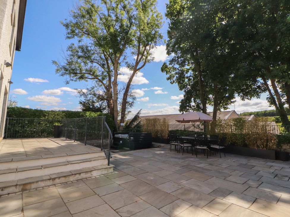 An outdoor patio with a dining set and trees at Ingleborough in Kirkby Lonsdale