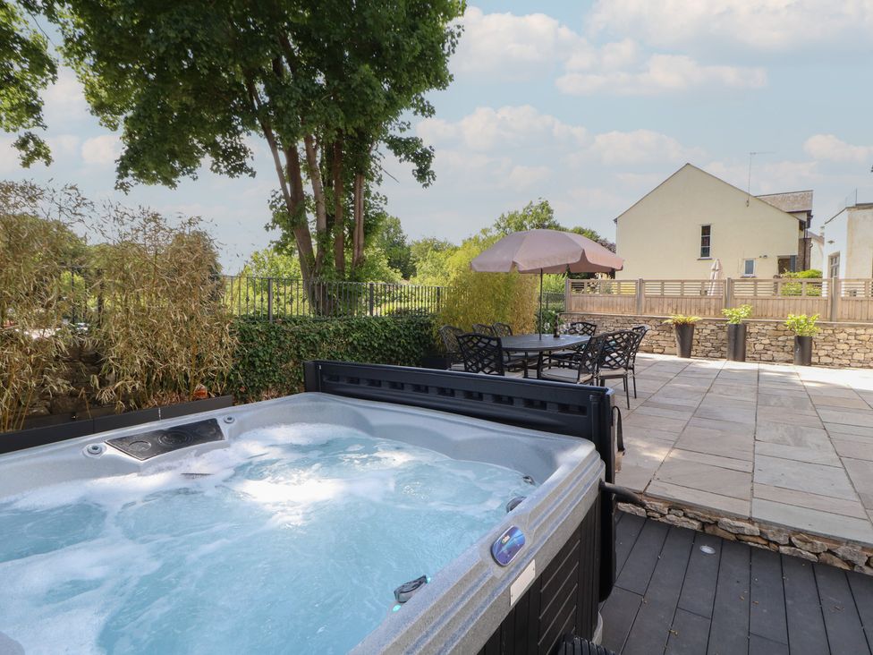 A hot tub on a patio area with furniture at Ingleborough, Kirkby Lonsdale
