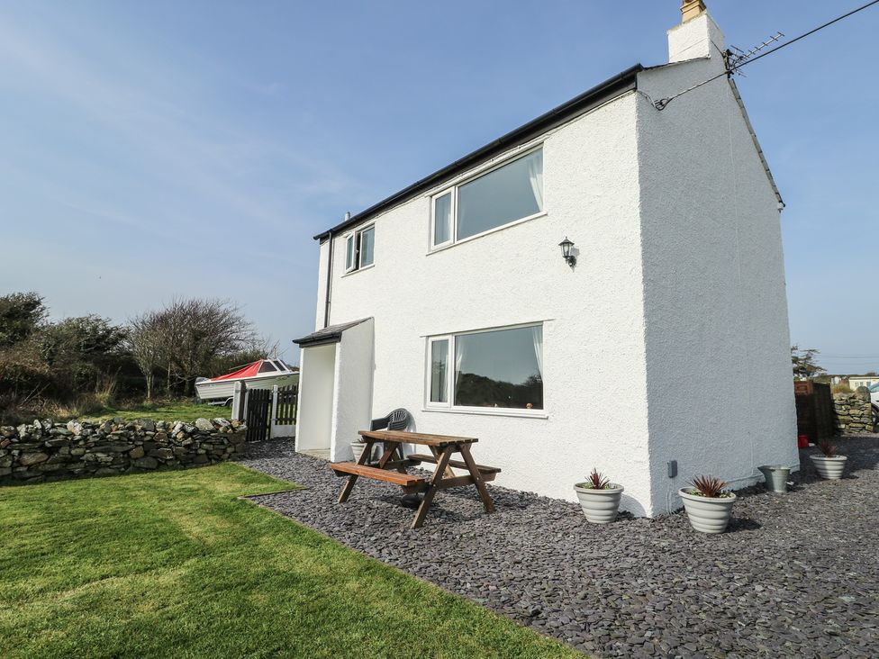 A house with a bench in the garden at Pentre Iago Rhoscolyn