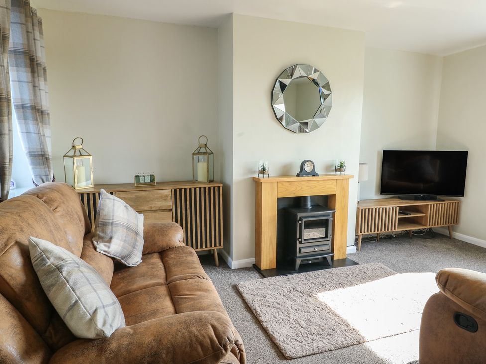 A living room with a sofa and TV at Pentre Iago in Rhoscolyn
