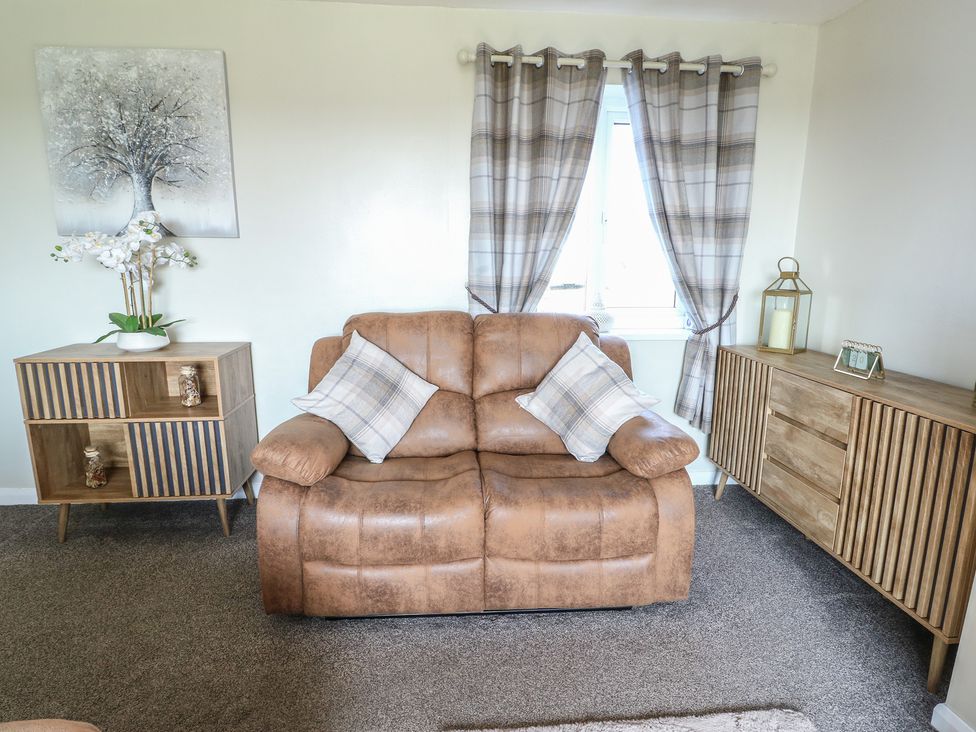 A living room with a sofa and decor at Pentre Iago Rhoscolyn