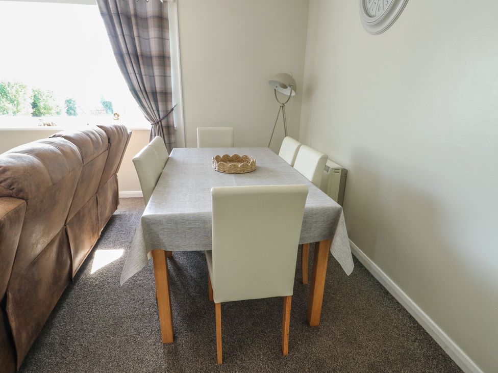 A dining room with a table and chairs at Pentre Iago Rhoscolyn