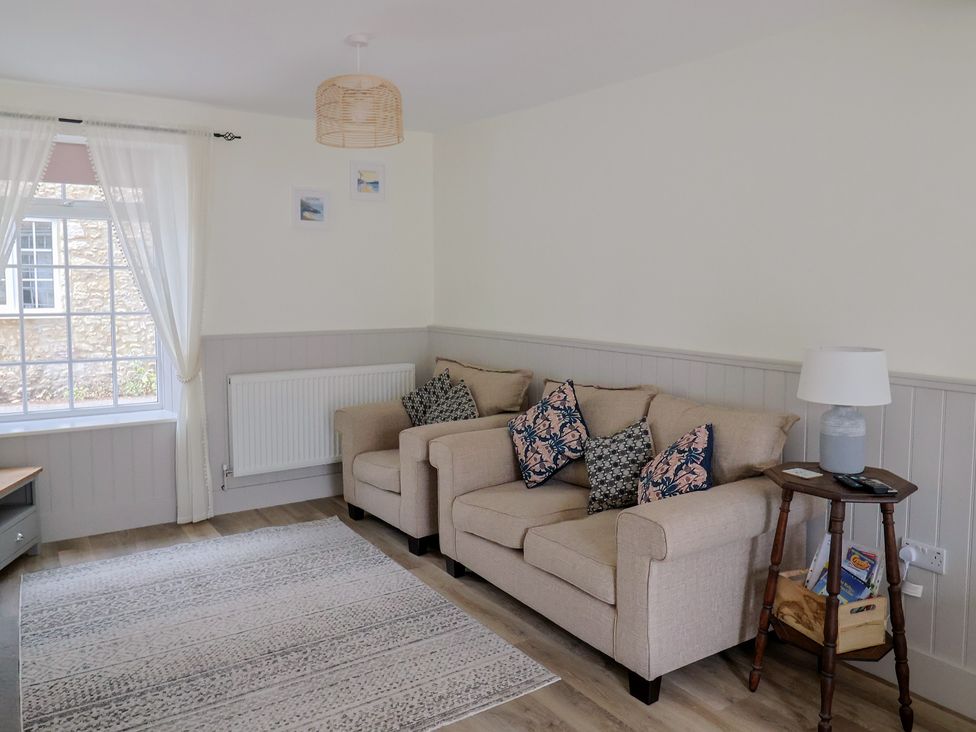 A living room with two sofas and a lamp at Belfry Cottage in Colyton