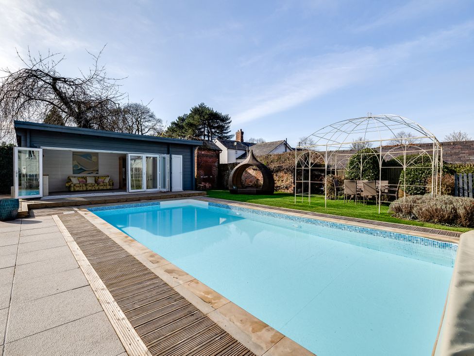 An outdoor area with a swimming pool and seating at The Old Chase in Chester