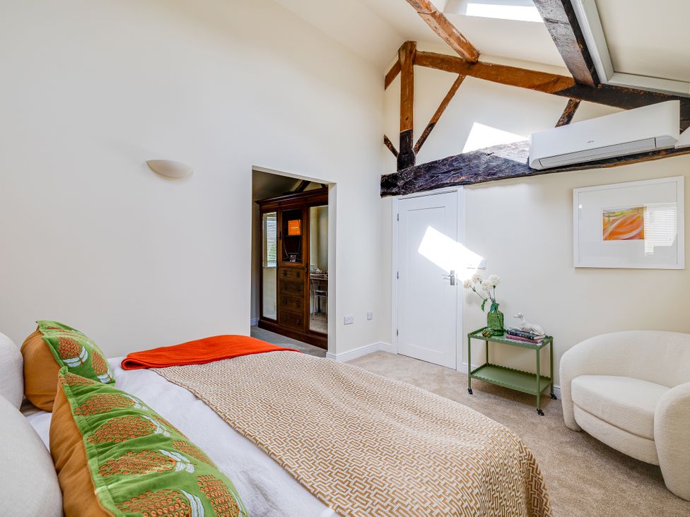 A bedroom with a bed and armchair at The Old Chase in Chester