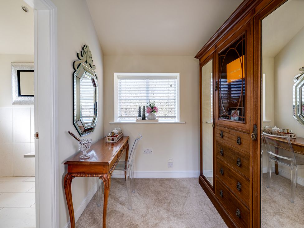 A hallway with a wooden cabinet and a mirror at The Old Chase in Chester