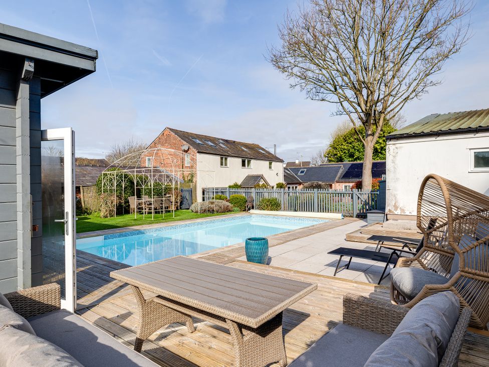 An outdoor area with a swimming pool and seating at The Old Chase in Chester