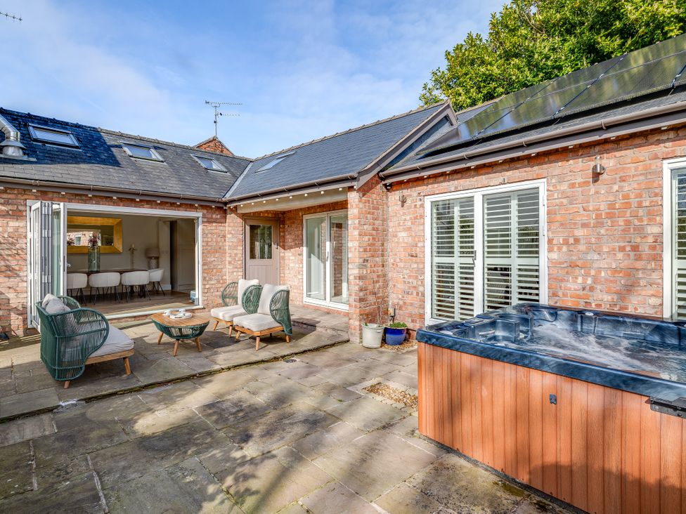 An outdoor area with a hot tub and seating at The Old Chase in Chester