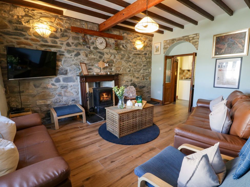 A living room with a fireplace and television at Parrog Stores near Newport, Pembrokeshire
