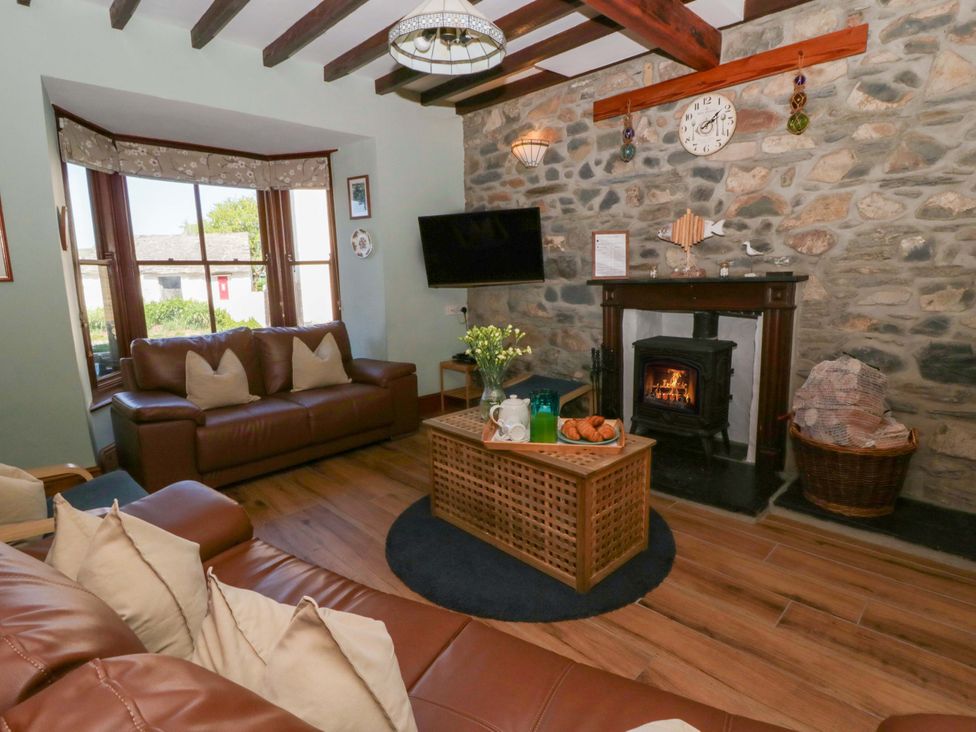 A living room with a sofa and fireplace at Parrog Stores Parrog near Newport, Pembrokeshire