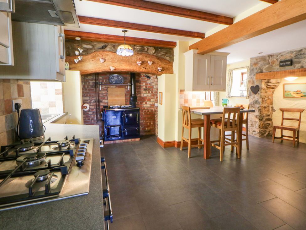 A kitchen with a stove and dining area at Parrog Stores in Parrog near Newport, Pembrokeshire