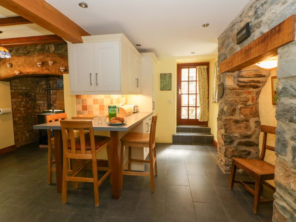 A kitchen with a dining area and a door at Parrog Stores Parrog near Newport, Pembrokeshire
