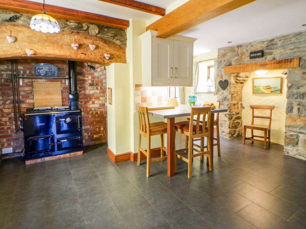 A kitchen with a stove and bar stools at Parrog Stores Parrog near Newport, Pembrokeshire