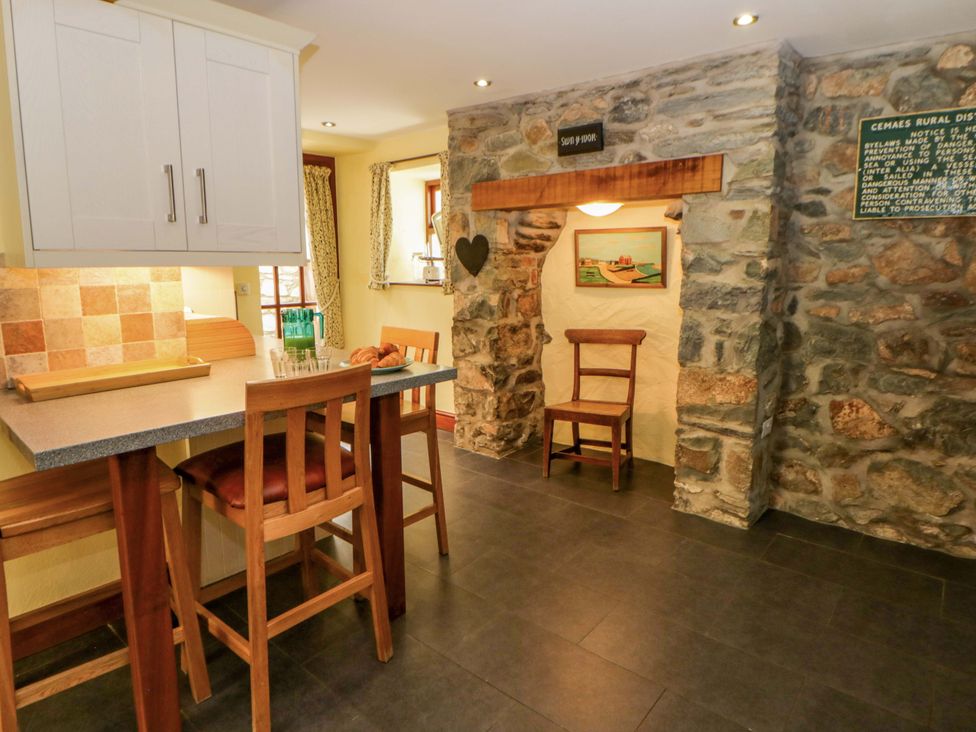 A kitchen with bar stools and stone wall at Parrog Stores near Newport, Pembrokeshire