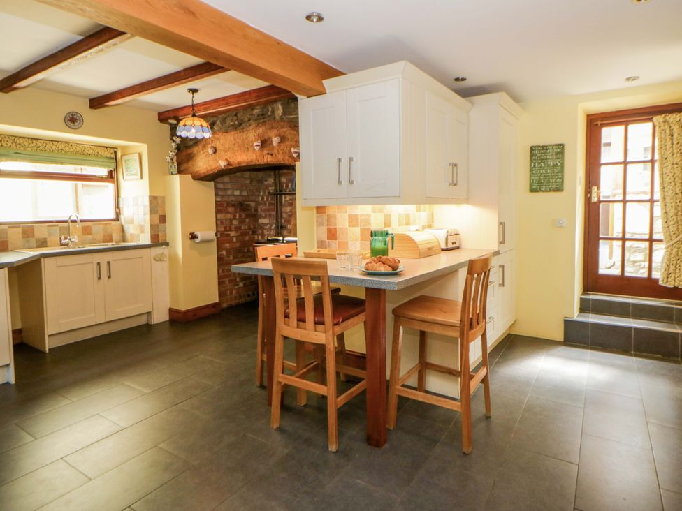 A kitchen with wooden chairs and a table at Parrog Stores near Newport, Pembrokeshire