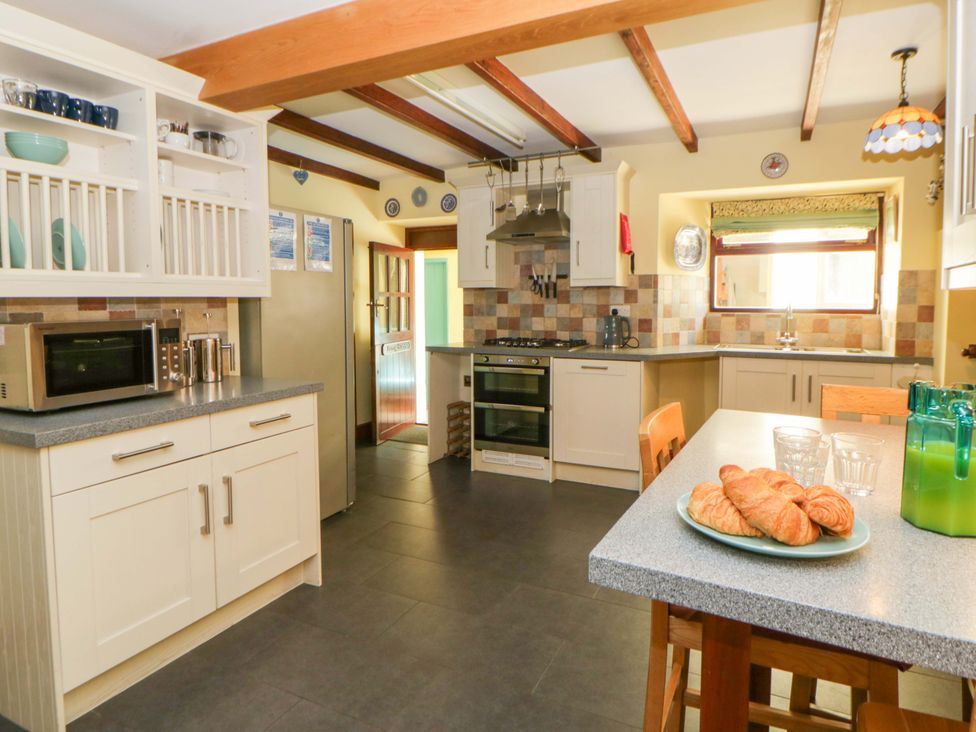 A kitchen with appliances and table at Parrog Stores near Newport, Pembrokeshire