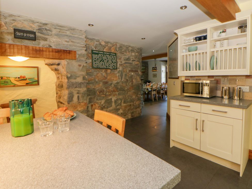 A kitchen with stone walls and a table at Parrog Stores Parrog near Newport, Pembrokeshire