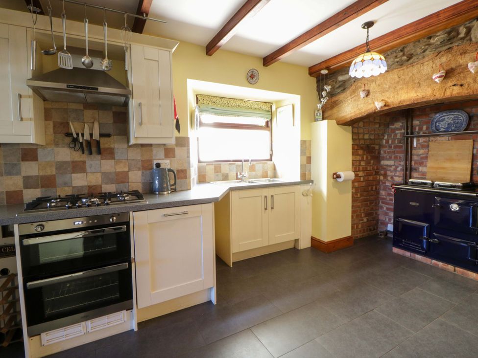 A kitchen with cabinets, stove, and sink at Parrog Stores near Newport, Pembrokeshire