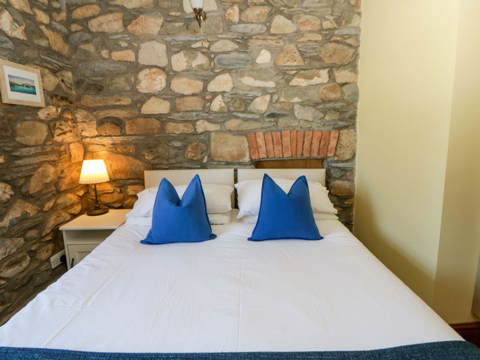 A bedroom with a bed and lamp at Parrog Stores near Newport, Pembrokeshire