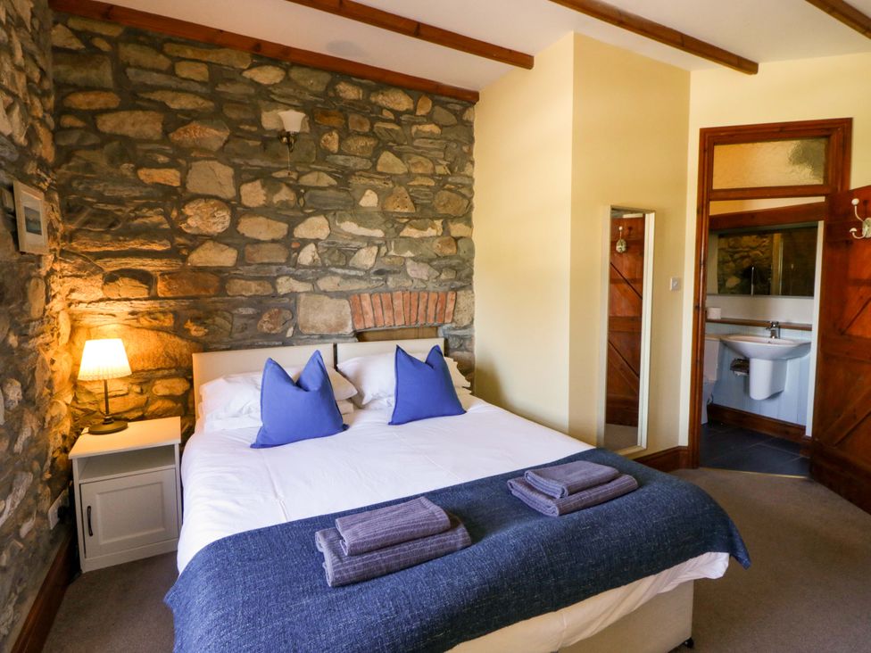 A bedroom with a bed and bathroom in Parrog Stores near Newport, Pembrokeshire