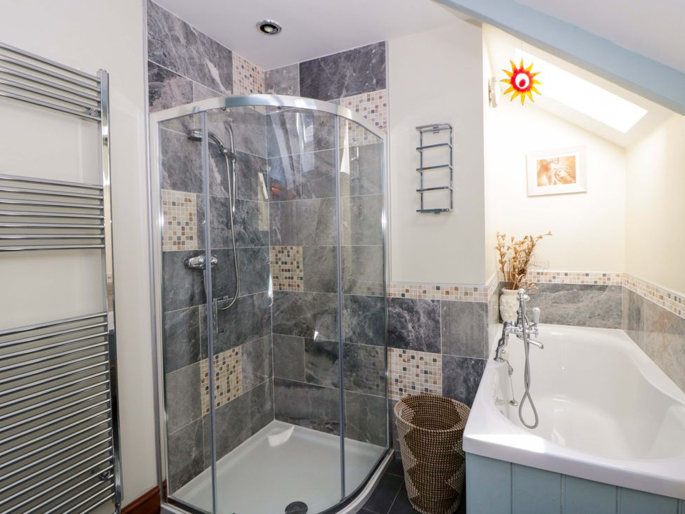 A bathroom with a shower and bathtub at Parrog Stores in Parrog near Newport, Pembrokeshire
