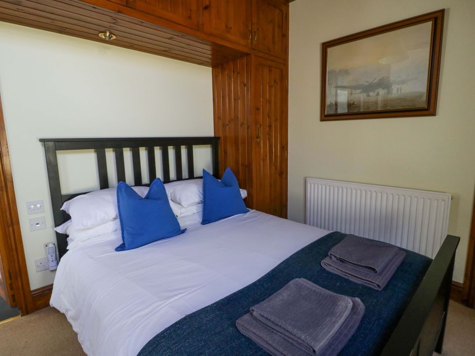 A bedroom with a bed and towels at Parrog Stores in Parrog near Newport, Pembrokeshire