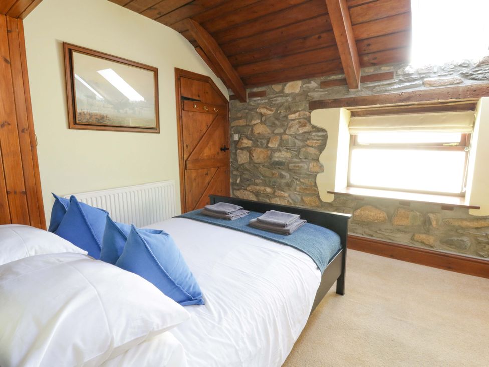 A bedroom with a bed and towels at Parrog Stores near Newport, Pembrokeshire