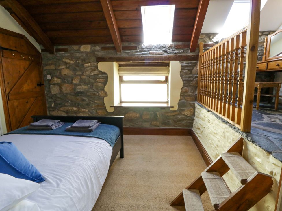 A bedroom with a bed and window at Parrog Stores Parrog near Newport, Pembrokeshire