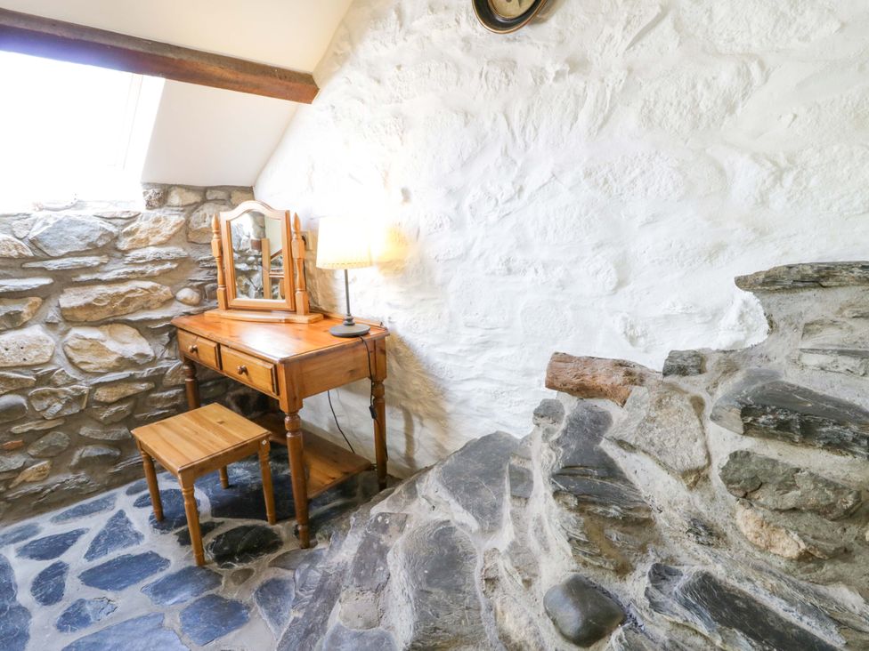 A bedroom with a dresser and lamp at Parrog Stores in Parrog near Newport, Pembrokeshire